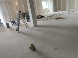 Unfinished room with drywall, a ladder, construction tools, and materials scattered across the floor.