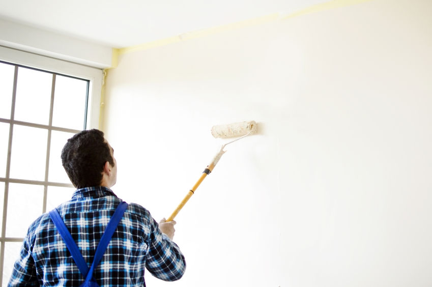 The process of painting the walls in the room using paint roller